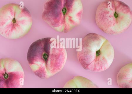 flat peaches isolated on pink background. figs peaches. fresh delicious peaches. copy space Stock Photo