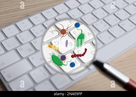 Magnifying glass detecting microbes on keyboard, closeup Stock Photo
