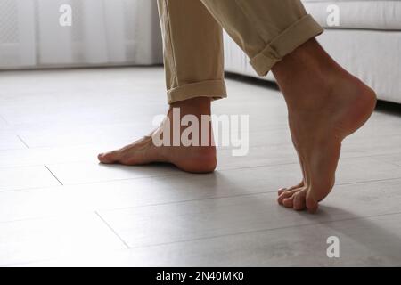 Man walking barefoot at home, closeup. Floor heating concept Stock Photo