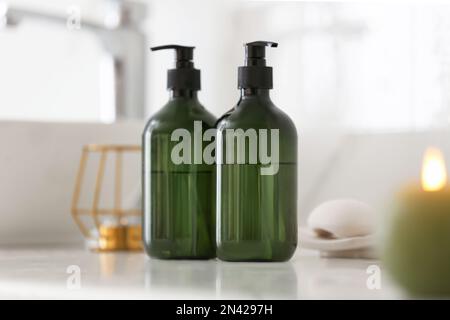 Green soap dispensers on white countertop in bathroom Stock Photo