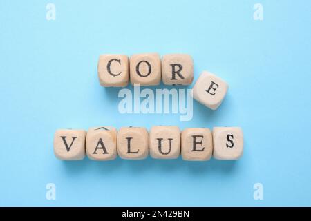 Beads with phrase CORE VALUES on light blue background, flat lay Stock Photo