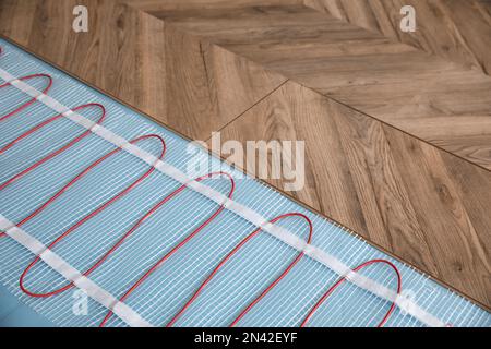 Installation of modern underfloor trace heating system indoors Stock Photo