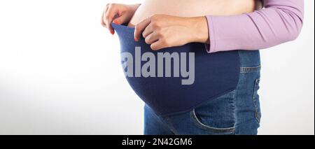 Pregnant Girl with a Big Belly in Jeans on a White Background. the Concept  of Comfortable Clothes for Pregnant Women, Universal Stock Image - Image of  corset, medical: 271887581