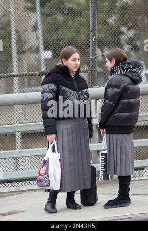 2 modestly dressed orthodox Jewish girls have a conversation. The matching pleated skirts are school uniforms.In brooklyn New York Stock Photo Alamy