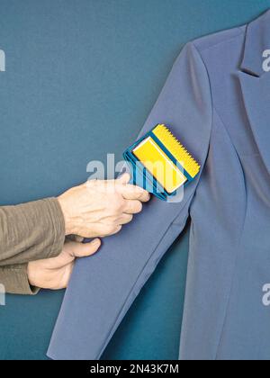 Cleaning the suit from dust with a special sticky roller. Stock Photo