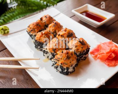 Rolls with eel, shiitake mushrooms, black sesame, spicy sauce, unagi sauce, pickled ginger. Asian cuisine, traditional dish - sushi. Stock Photo