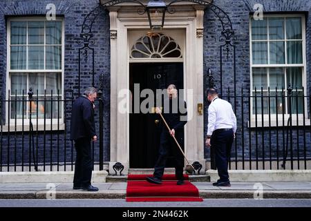 Downing Street staff lay out the red carpet in front of 10 Downing Street, London, ahead of the arrival of Ukrainian President Volodymyr Zelensky, for a bilateral meeting with Prime Minister Rishi Sunak, during his first visit to the UK since the Russian invasion of Ukraine. Picture date: Wednesday February 8, 2023. Stock Photo