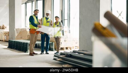 Building, construction and architect with a team working on site while reading a blueprint or plans indoors. Teamwork, engineer and architecture with Stock Photo