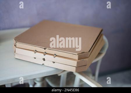 Cardboard pizza boxes on kitchen in table. Stock Photo