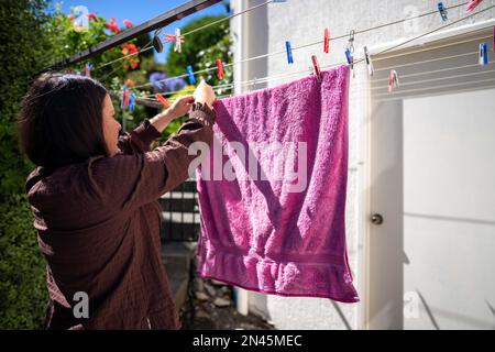 Drying clothes on a clothesline. drying a towel outside in Australia using pegs Stock Photo