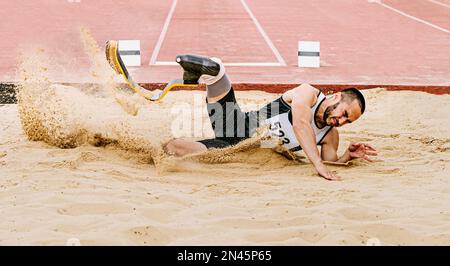 disabled athlete landing sand in long jump Stock Photo