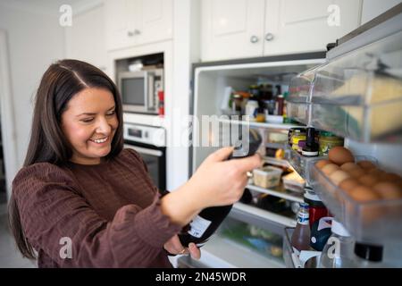 Getting food out of the fridge. Beer in the fridge. Fridge full of food. Freezer full of food. Person deciding what they what for dinner from the frid Stock Photo