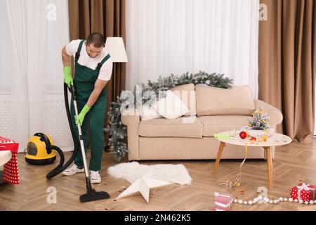 Male worker removing dirty stain from grey sofa with vacuum cleaner in room  Stock Photo - Alamy