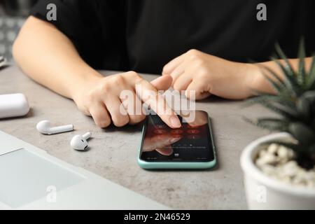 MYKOLAIV, UKRAINE - JULY 9, 2020: Woman entering passcode on Iphone 11 at table, closeup Stock Photo