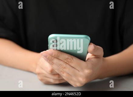 MYKOLAIV, UKRAINE - JULY 9, 2020: Woman holding Iphone 11 Green at table, closeup Stock Photo