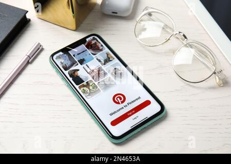 MYKOLAIV, UKRAINE - JULY 10, 2020: New modern Iphone 11 and glasses on white wooden table Stock Photo