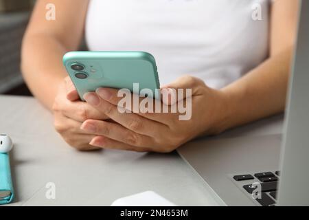 MYKOLAIV, UKRAINE - JULY 10, 2020: Woman using Iphone 11 Green at table, closeup Stock Photo