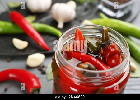 Glass jar of tasty pickled chili peppers, closeup Stock Photo