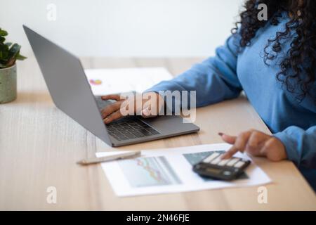 Unrecognizable woman accountant using computer and calculator Stock Photo