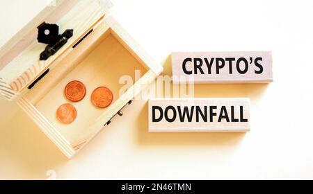 Crypto downfall symbol. Concept words Cryptos downfall on wooden blocks. Beautiful white table white background. Wooden chest with coins. Business and Stock Photo