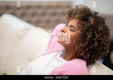 Profile shot of joyful african american lady relaxing at home Stock Photo