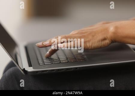 Black female hands typing text on laptop keyboard. Unrecognizable BIPOC woman working on modern notebook pc in close up Stock Photo