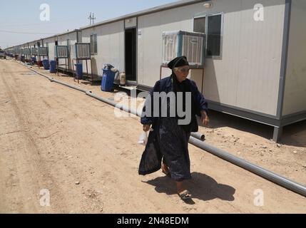 An Iraqi Shiite woman of those who fled from Mosul, Iraq, and other towns after the advance of Islamic militants walks at a refugee camp in Baghdad's southeast suburb of Nahrawan, Iraq, Sunday, Aug. 17, 2014. (AP Photo/ Karim Kadim)