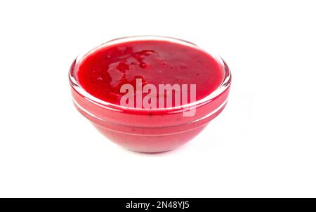 Glass bowl with liquid red berry sauce as dressing for meat, food Stock Photo