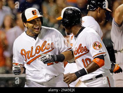 Baltimore Orioles' Nelson Cruz, left, celebrates with teammates J.J. Hardy  (2) and David Lough after Hardy and Lough scored on a double by Jimmy  Paredes in the 11th inning in the first