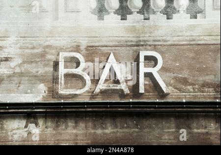 old  bar sign and and electrical conduit pipes on wall Stock Photo