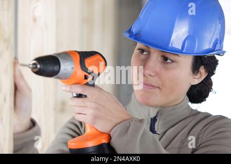 female construction worker using cordless drill Stock Photo