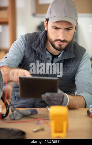 it technician holding tablet surrounded by circuit boards Stock Photo