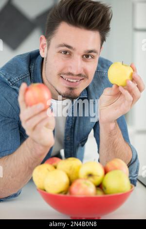 happy young man takes apples Stock Photo