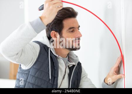 service man installing window with measure tape Stock Photo