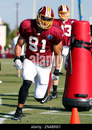 New York Giants running back Saquon Barkley (26) runs past Washington  Redskins outside linebacker Ryan Kerrigan (91) after making a reception in  the first quarter against the Washington Redskins at FedEx Field