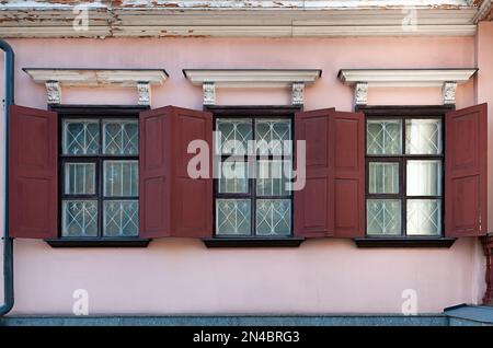Three windows with shutters on the old building wall in Kyiv Ukraine Stock Photo