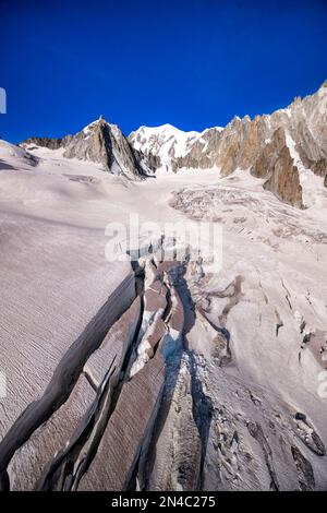 View of the slopes and crevasses of the upper part of the Géant Glacier, the summits of La Tour Ronde and Mont Blanc in the distance. Stock Photo