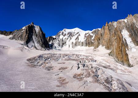 View of the slopes and crevasses of the upper part of the Géant Glacier, the summits of La Tour Ronde and Mont Blanc in the distance. Stock Photo