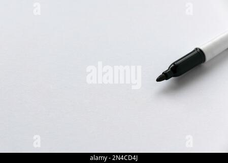 Permanent black marker pen on a white paper with copy space. Stock Photo