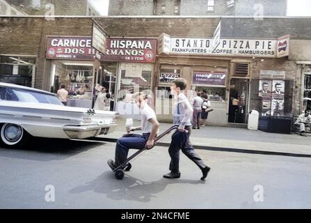 Two Boys in Street, one riding on Hand Truck, New York City, New York, USA, Angelo Rizzuto, Anthony Angel Collection, July 1964 Stock Photo