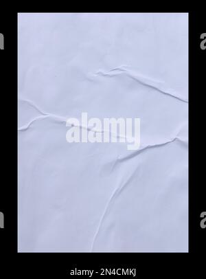 Blank white crumpled and creased sticker glued paper poster texture isolated on black background. Stock Photo