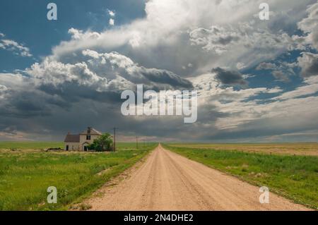 Stormy skies over a rural dirt road and an abandoned home seem to usher in the summer monsoon season. Stock Photo