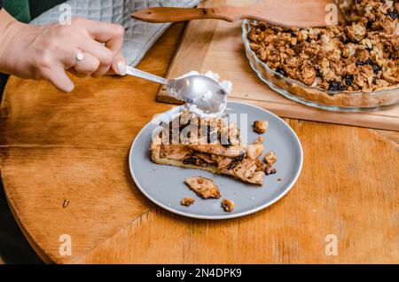 A piece of sweet cake with nuts, apples on a blue plate Stock Photo