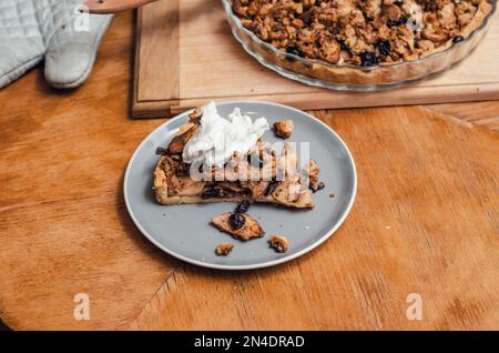 A piece of sweet cake with nuts, apples on a blue plate Stock Photo