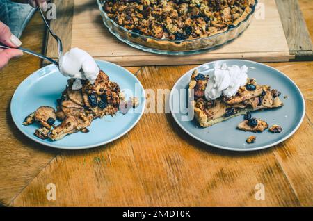 A piece of sweet cake with nuts, apples on blue plate Stock Photo