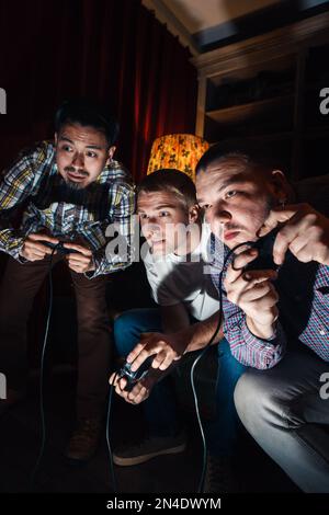 Video game tourney, young guys play with joysticks Stock Photo