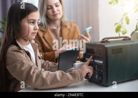 The inverter generator charges the power bank battery Stock Photo