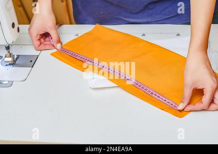 https://l450v.alamy.com/450v/2n4ea9a/dressmaker-measures-the-cloth-for-sewing-clothes-with-measuring-tape-2n4ea9a.jpg