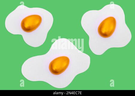 Creative layout made of scrambled eggs with decorated golden Easter eggs on a green background. Minimal blue pattern background. Spring holidays conce Stock Photo