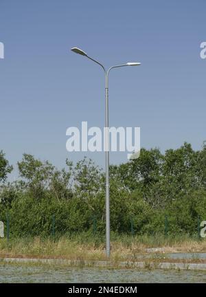 one street pole with two lanterns in nature in the summer day Stock Photo